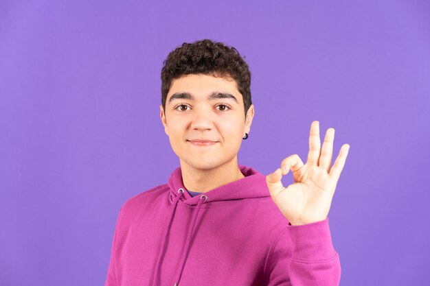 Positive hispanic teenager boy making ok sign