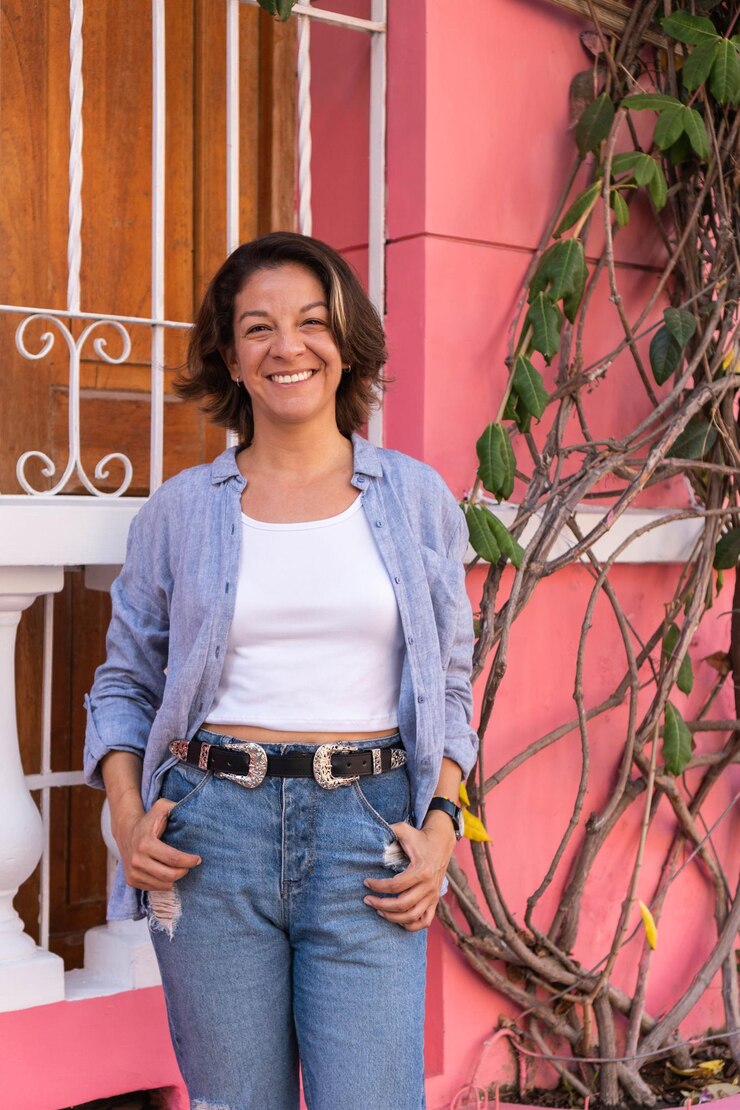 Photo positive hispanic woman leaning against a pink wall