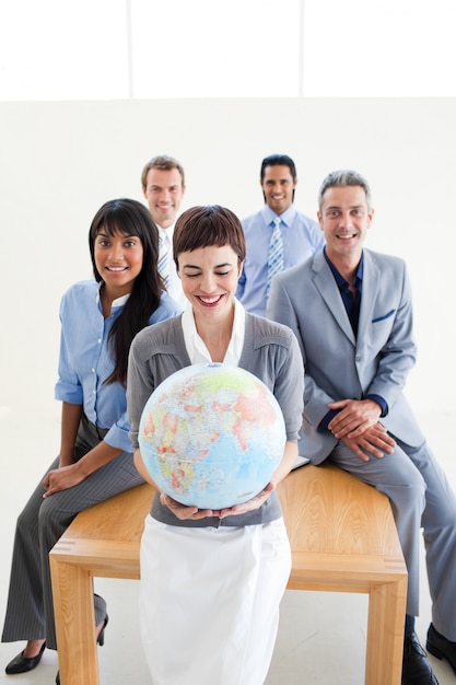 Positive international business people holding a terrestrial globe