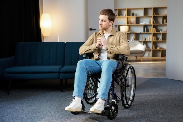 Positive lifestyle care for disabled person rehabilitation and support at home Young caucasian man in wheelchair in living room