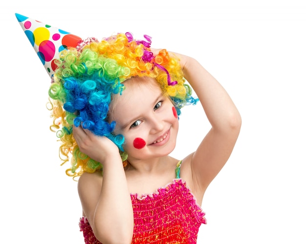 Positive little girl posing in colorful clown wig isolated on white background