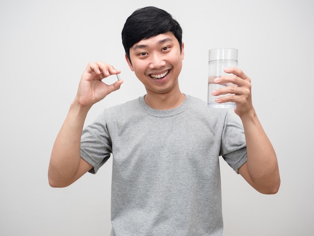 Positive man fresh healthy holding vitamin with glass of water happy smile isolated