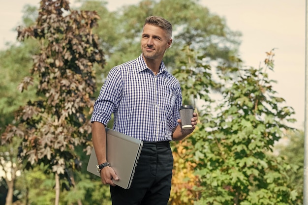 Foto uomo positivo uomo portatile uomo freelance uomo d'affari all'aperto con pc