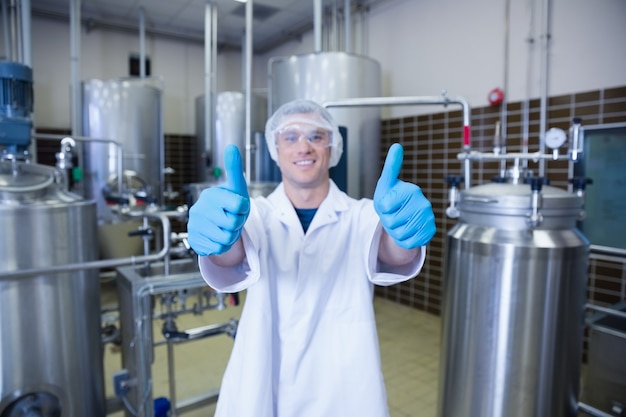 Positive man in lab coat giving thumbs up