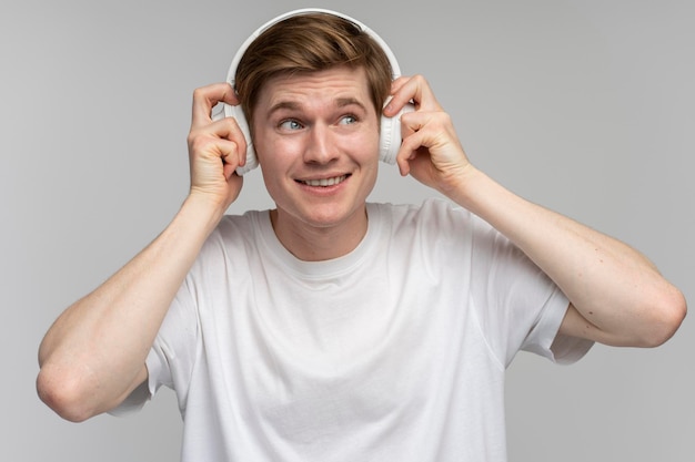 Positive man listening to music wearing headset and dancing