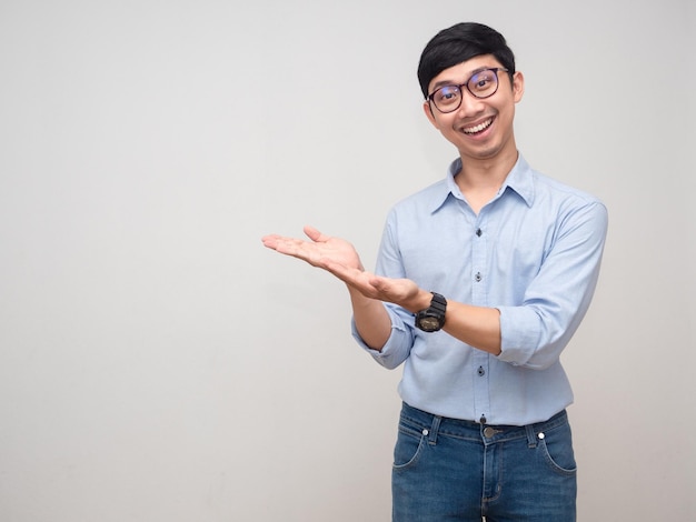 Positive man wear glasses smile and show hands up for suggest