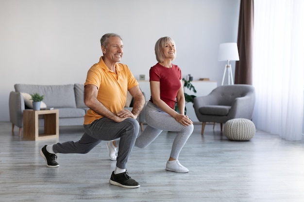 Positive mature couple having workout at home copy space