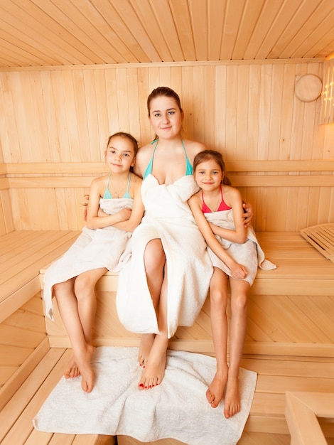 Фото Позитивная мать с дочерьми отдыхает в паровой бане