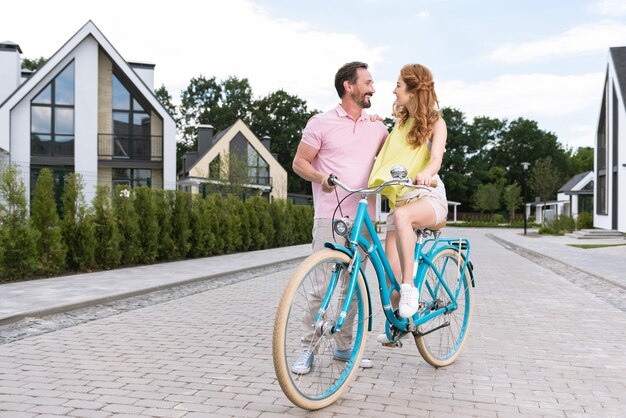 Positive nice couple riding a bicycle while having a date