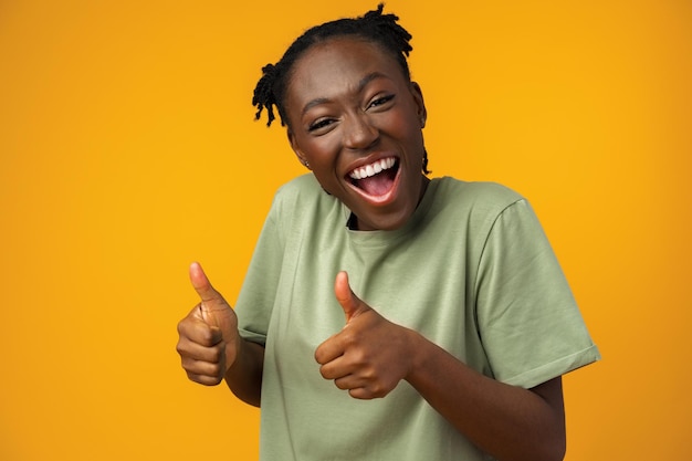 Positive nice girl showing you ok sign against yellow background