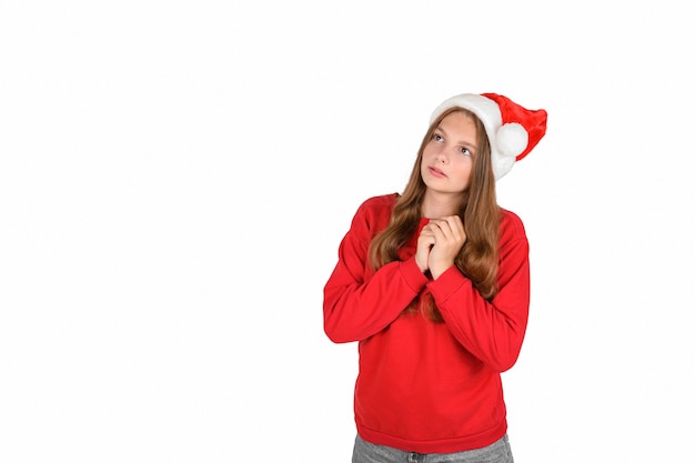 Positive optimistic pretty woman in casual red sweater and santa hat dreamy expecting christmas