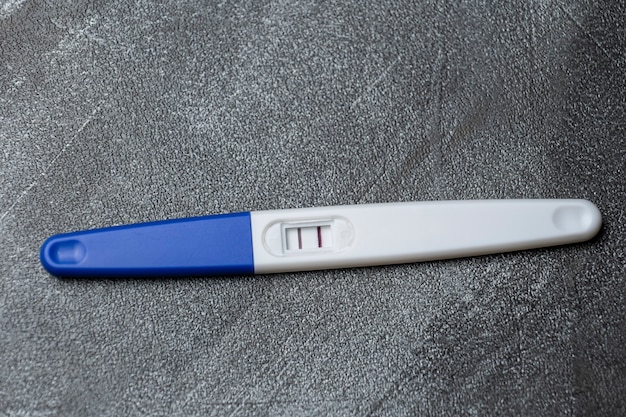 Positive pregnancy test on gray surface