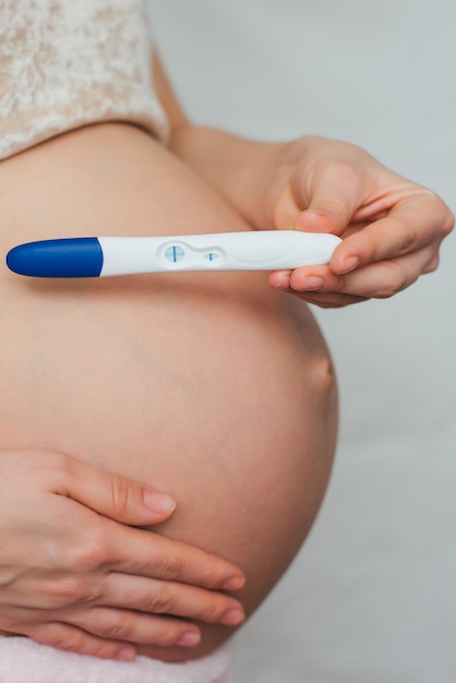 Positive pregnancy test in the hands of a pregnant woman