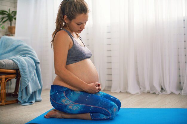 Положительная беременная женщина делает йогу