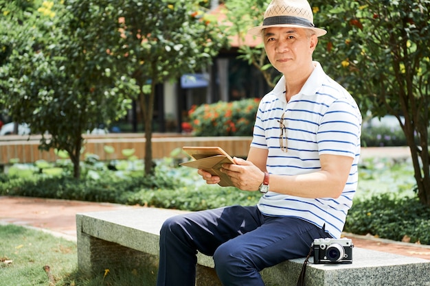 Uomo asiatico senior positivo nel parco