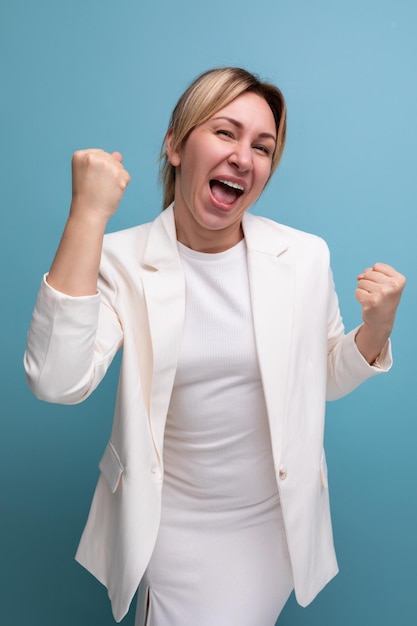 Positive slim young caucasian blond lady in white jacket and dress shares ideas