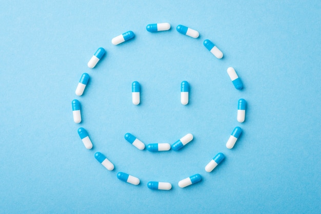 Положительная улыбка из таблеток на синем фоне