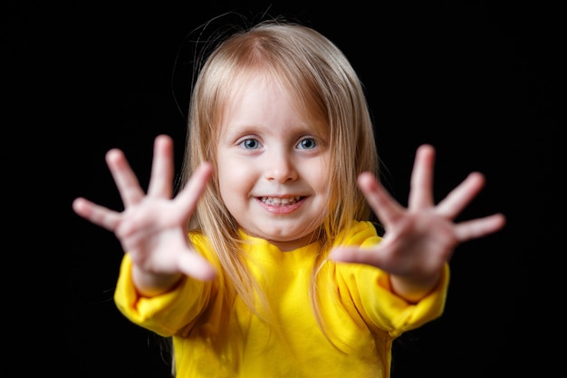 写真 黄色い服を着た前向きな笑顔の女の赤ちゃん