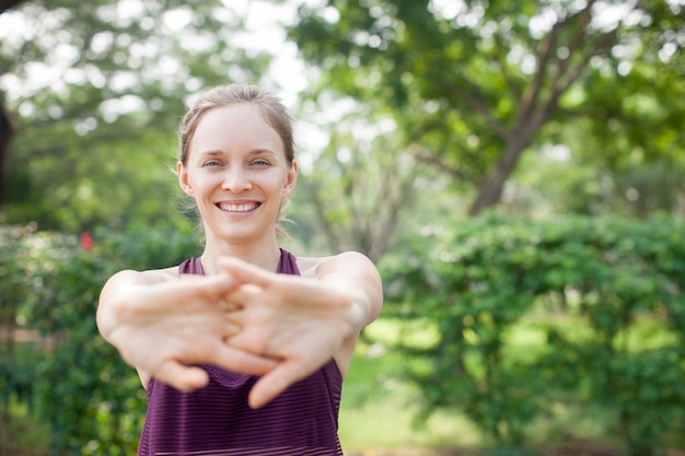 Photo positive sporty woman stretching clasped hands