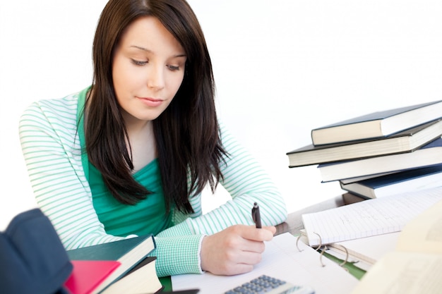 Positive student doing her homework on a desk 