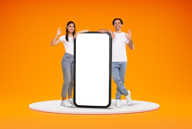 Positive stylish young man and woman with huge phone