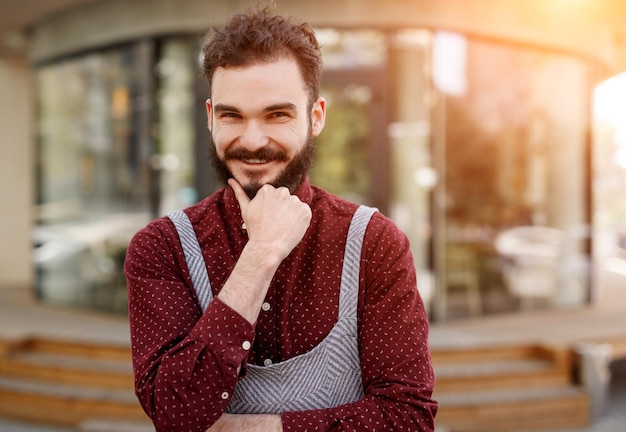 Positive waiter standing outside restaurant