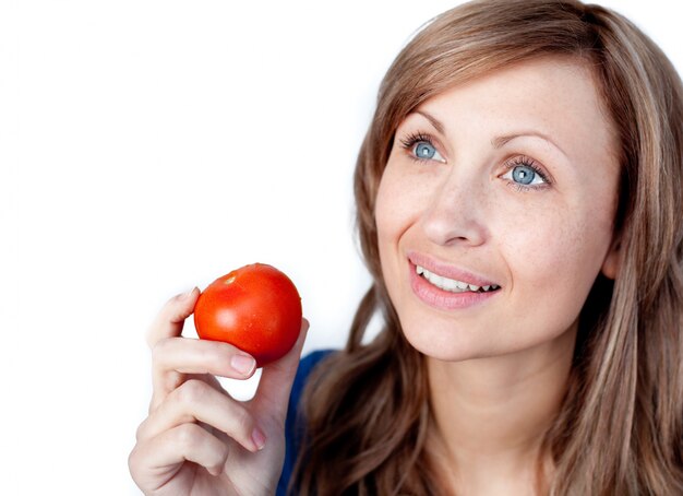 Positive woman holding a tomato