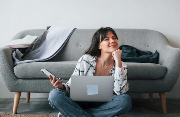 Positive woman is smiling Young female freelance worker is indoors in home at daytime