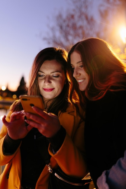 Photo positive women browsing smartphone at night