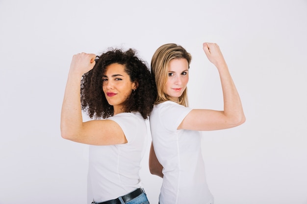 Foto donne positive che mostrano i muscoli