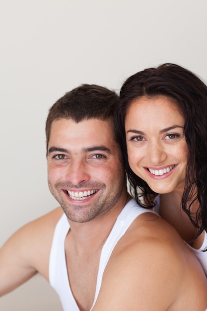 Positive young couple sitting on the bed