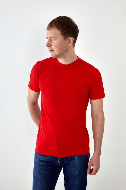 Positive young man in casual outfit standing on white background