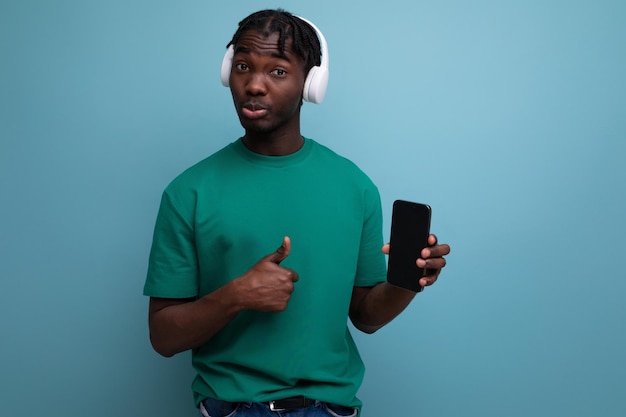 Positive young man listening to music using headphones and smartphone