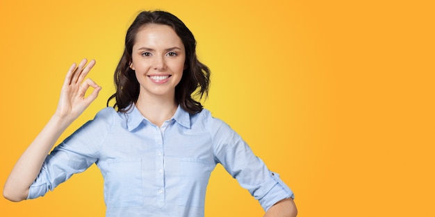 Positive young woman expressing happiness and showing OK