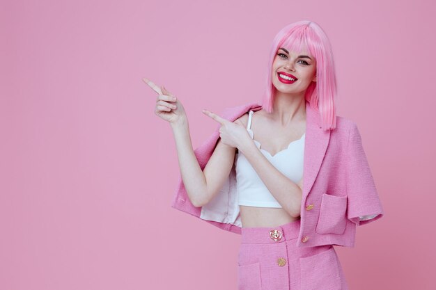 Positive young woman in a pink suit gesturing with his hands emotions fun pink background unaltered