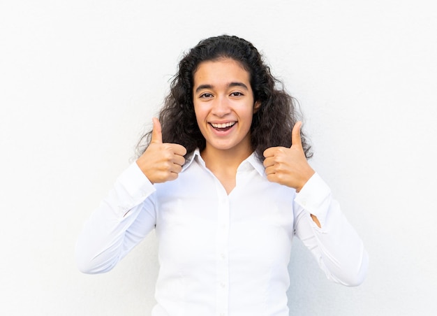 Positive young woman portrait against wall