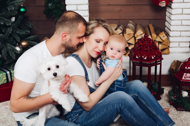 Famiglia di positività che propone insieme vicino al camino e regali per natale