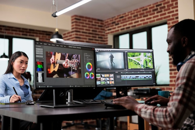 Post production department team leader editing movie footage using advanced technology software. Creative agency professional editor enhancing video film quality while sitting at desk.