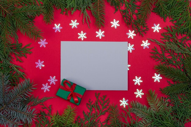 Photo postcard in a frame made of branches of a christmas tree and a gift