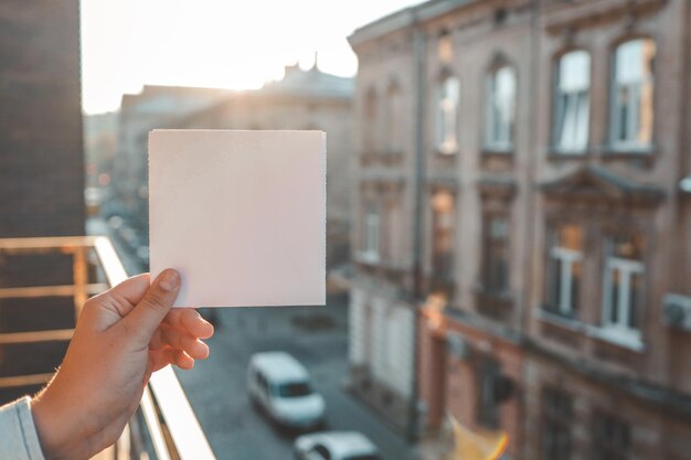 Foto modello di cartolina in mano sullo sfondo di una città antica