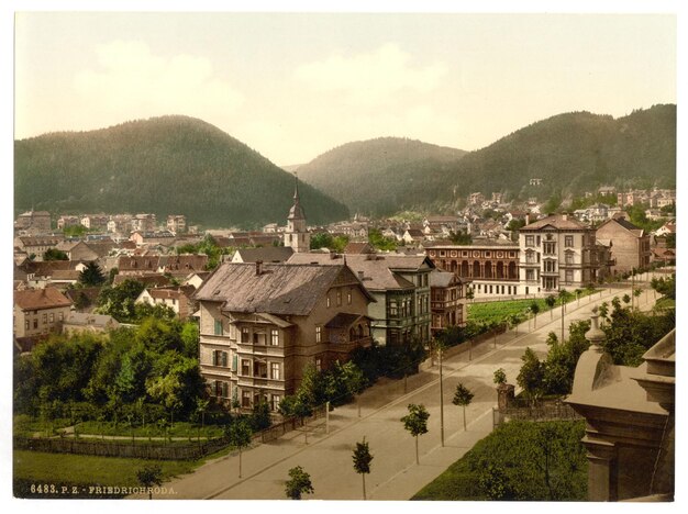 Photo a postcard of a town with a mountain in the background