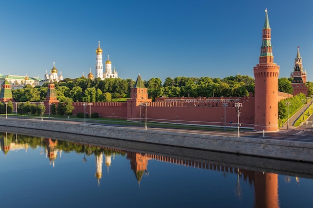 Postcard view of Kremlin churches with golden domes trees and reflection in river Moscow Russia