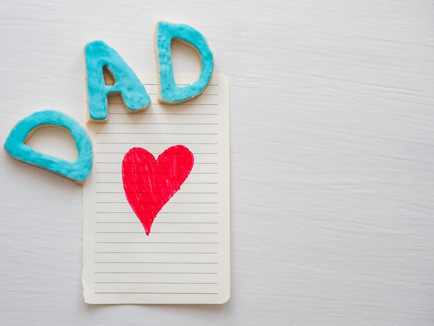 Postcard with painted red heart and word DAD