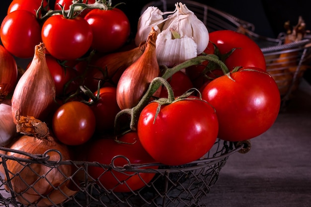 Poster di un vecchio cestino con pomodori aglio cipolla per decorare la cucina