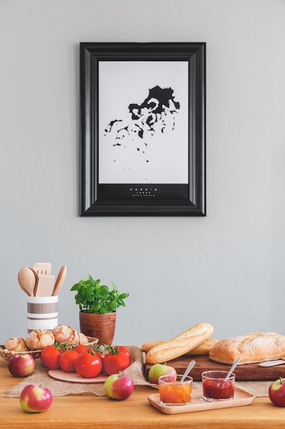 Foto poster op grijze muur in eetkamer interieur met basilicum, tomaten en baguettes op houten tafel echte foto