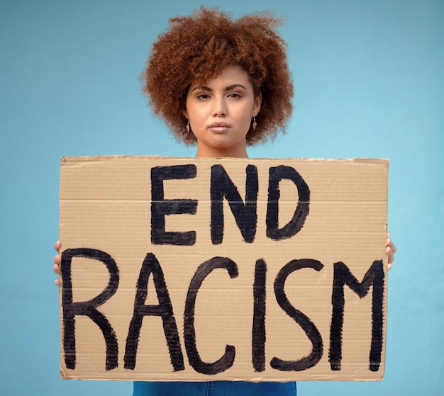 Photo poster political and portrait of a woman in a studio for a protest for racism equality and human rights freedom social justice and female from mexico with a sign for a rally by a blue background