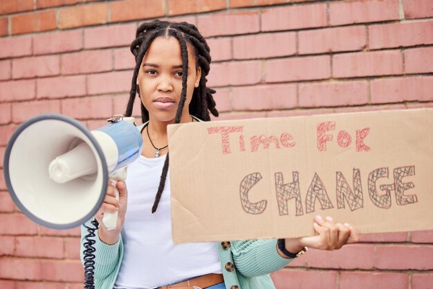 Foto ritratto di poster e donna sul megafono per protesta contro il cambiamento o diritti umani sullo sfondo del muro di mattoni altoparlante banner e volto di ragazza per l'annuncio della trasformazione globale o della missione di libertà