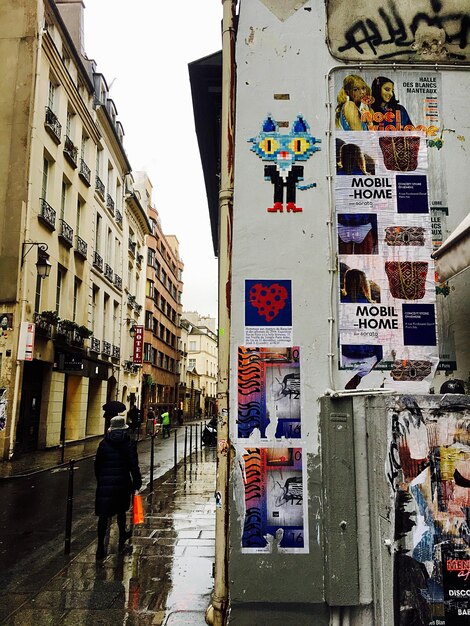 Foto poster sul muro di una donna che cammina su un sentiero bagnato