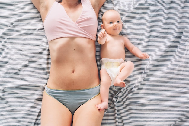 The postpartum or postnatal period Young mother with visible postpartum body marks and baby