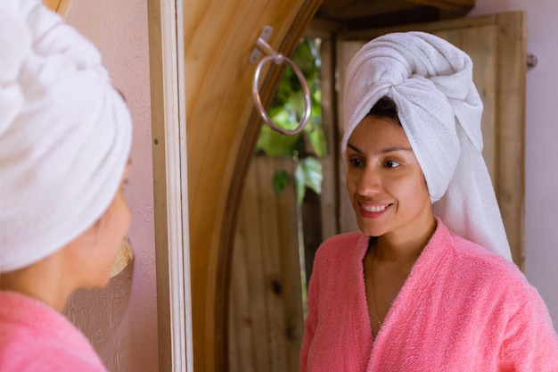 Foto postshower bliss vrouw met handdoek op hoofd glimlachend in glamping badkamerspiegel